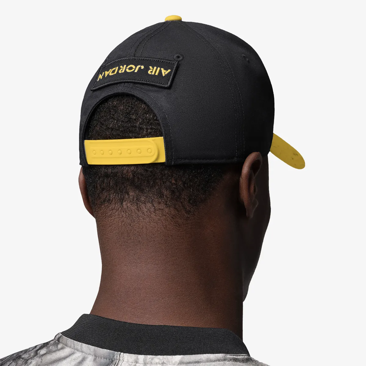Back view of a black Jordan Rise Tour cap with Tour Yellow snapback closure and Air Jordan branding.
