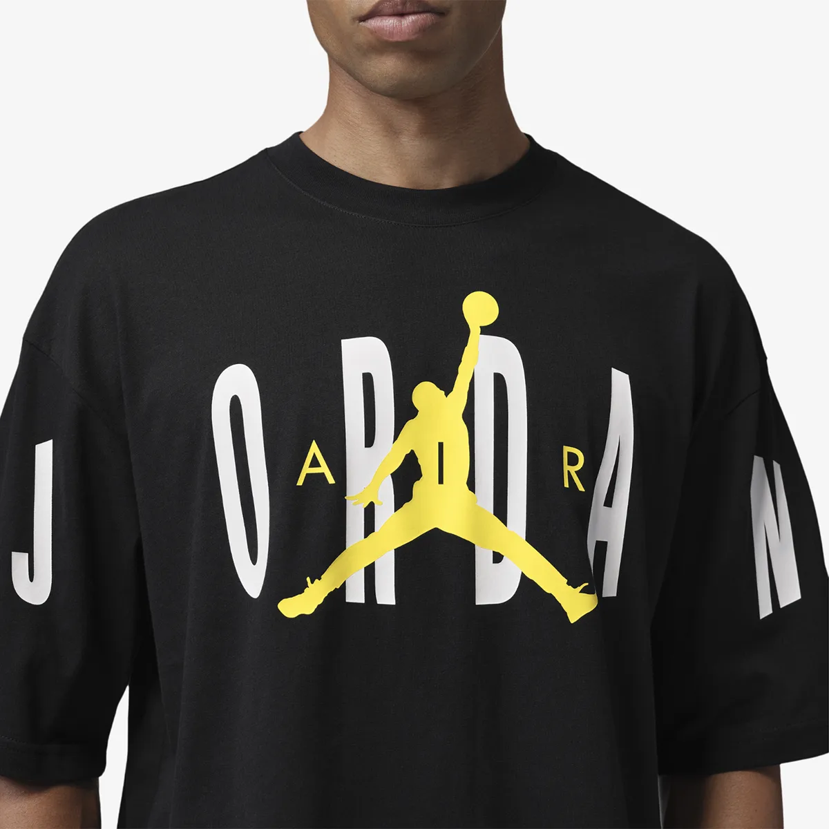 Close-up of the black Jordan Stretch Oversized T-Shirt with white Jordan lettering and a Tour Yellow Jumpman graphic.