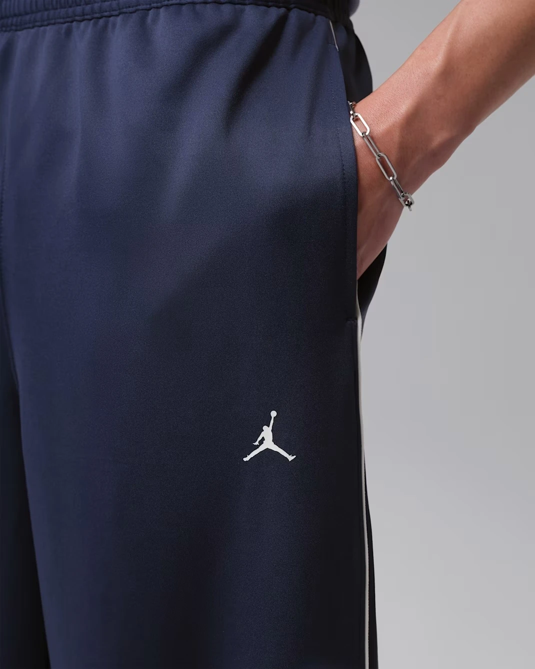 Close-up of the Jordan Jumpman Track Pants in Midnight Navy with white Jumpman logo matching the Air Jordan 13 "Flint" (2026).