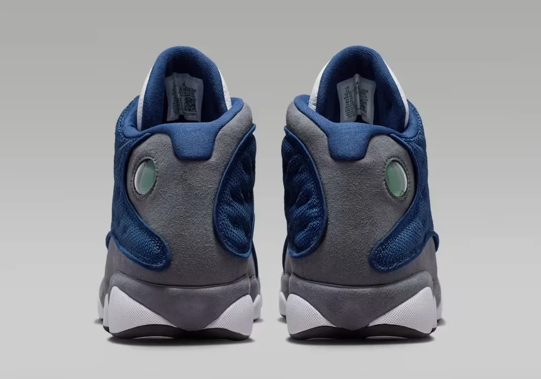 Heel view of the Air Jordan 13 "Flint" (2026) featuring the signature holographic cat-eye logo.