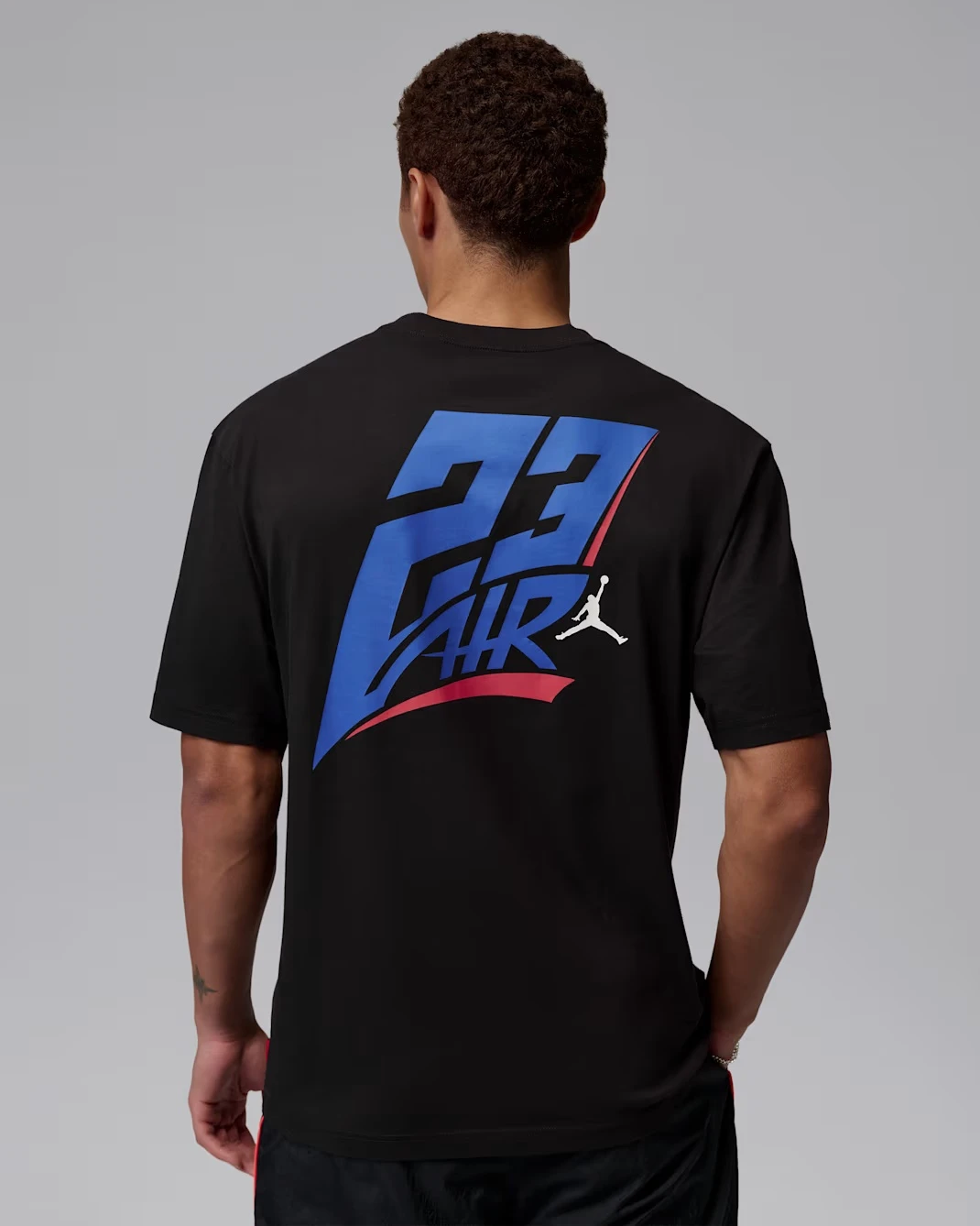 Back view of a black Jordan International Air Carriers T-shirt matched with the Air Jordan 3 True Blue.