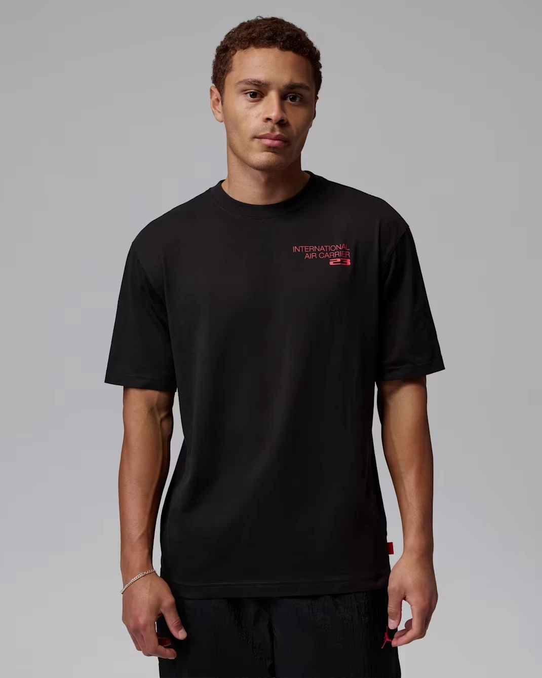 Front view of a black Jordan International Air Carriers T-shirt matched with the Air Jordan 3 True Blue.
