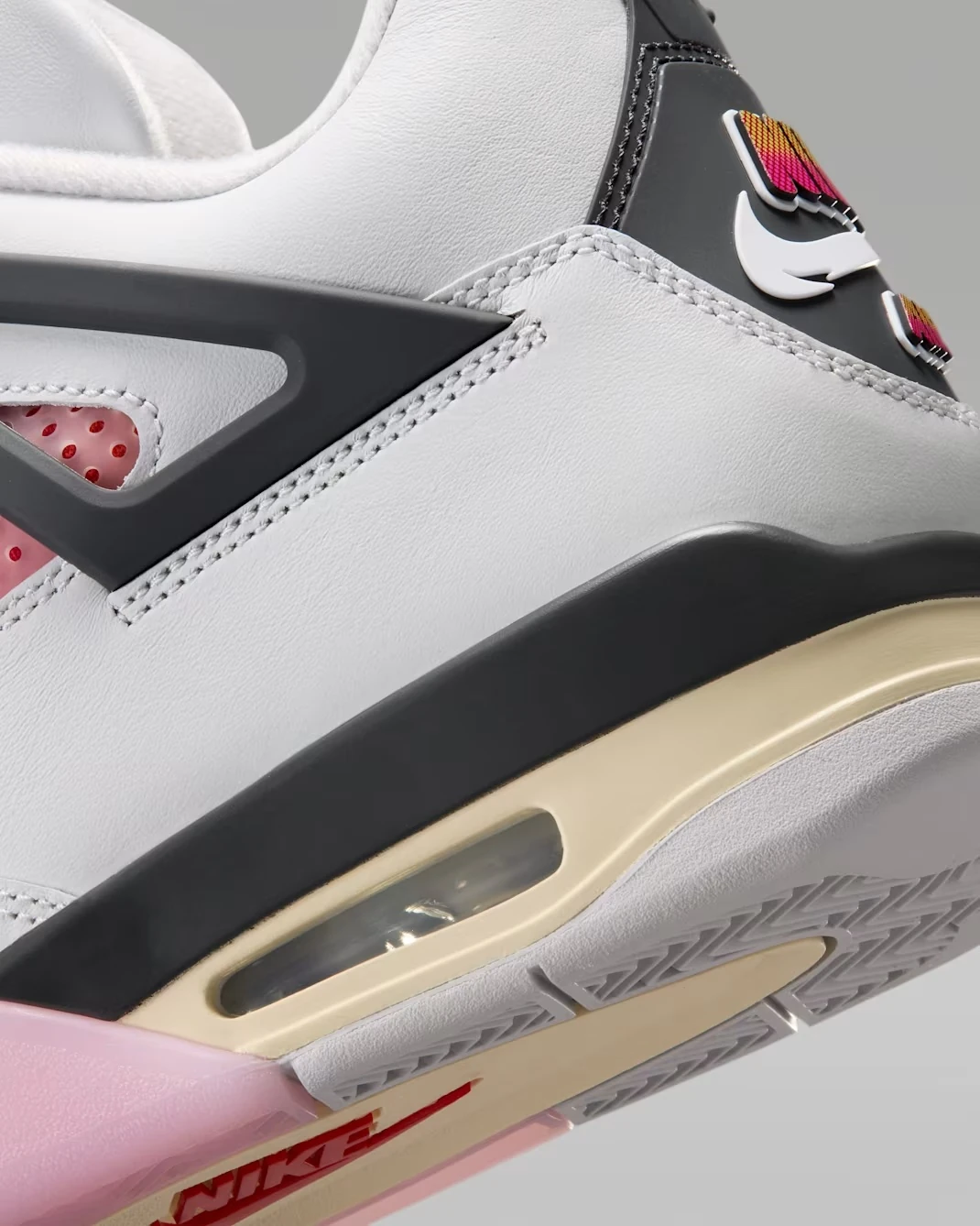 Close-up of the Air Jordan 4 Comic heel showing white leather, Anthracite support wing and aged midsole with visible Air unit.