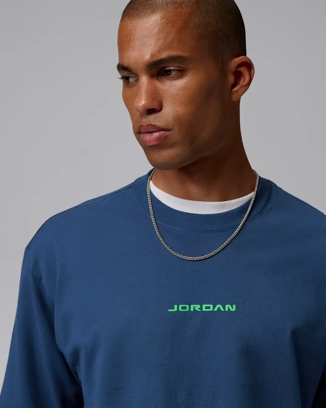Close-up of the French Blue Jordan AJ13 T-Shirt featuring the green Jordan logo on the chest.