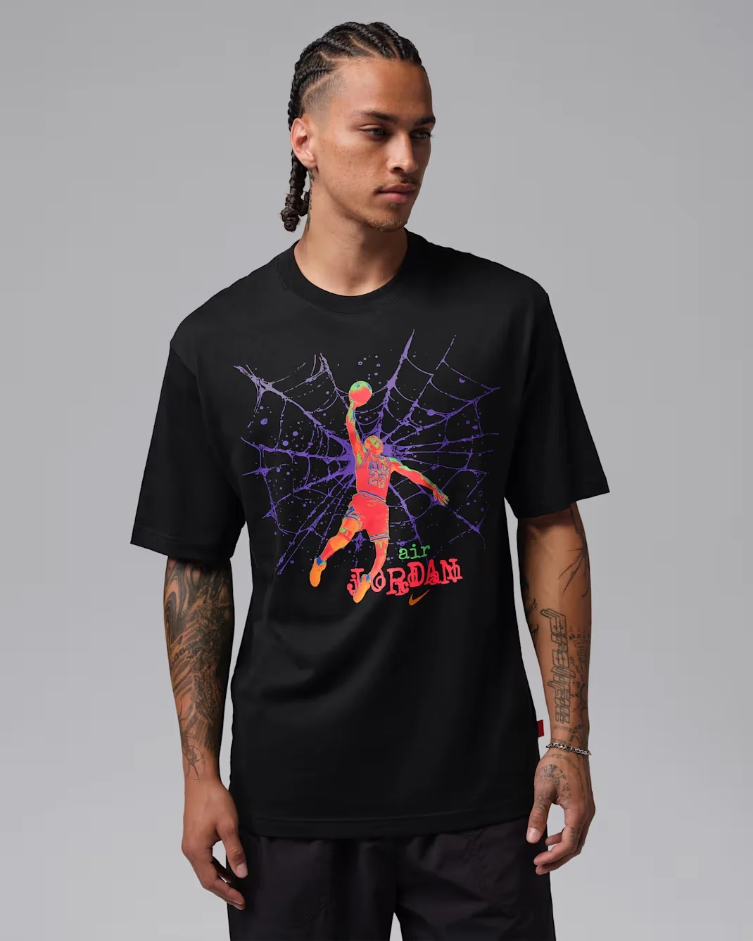 Model wearing a black Jordan Brooklyn graphic T-shirt with a purple spiderweb and colorful Michael Jordan basketball graphic.