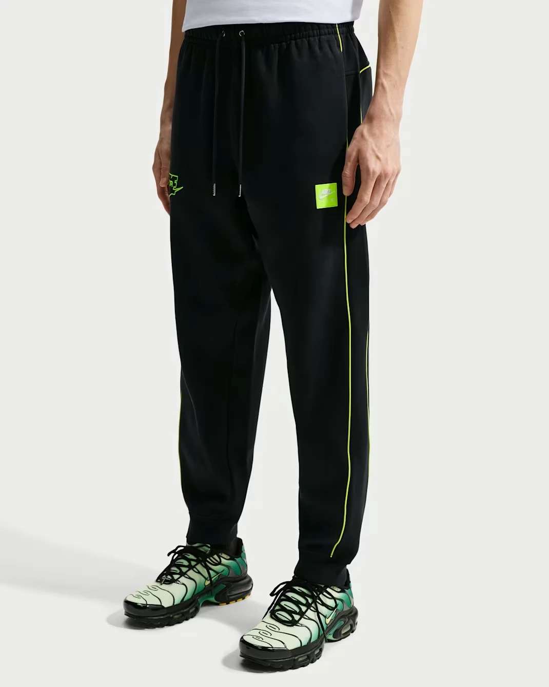 Front view of the Nike Air Fleece Joggers in black with Volt accents